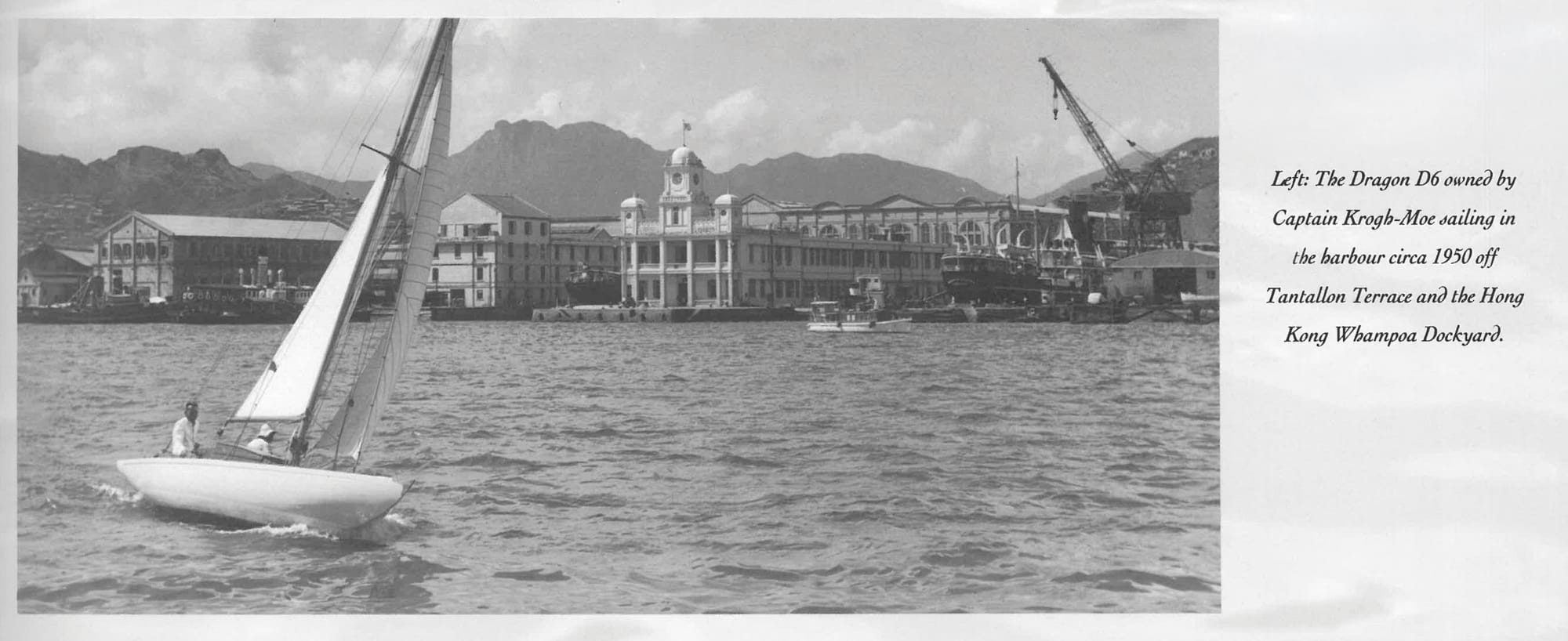 Black and white harbour scene circa 1950 with a sailboat and waterfront clock tower.