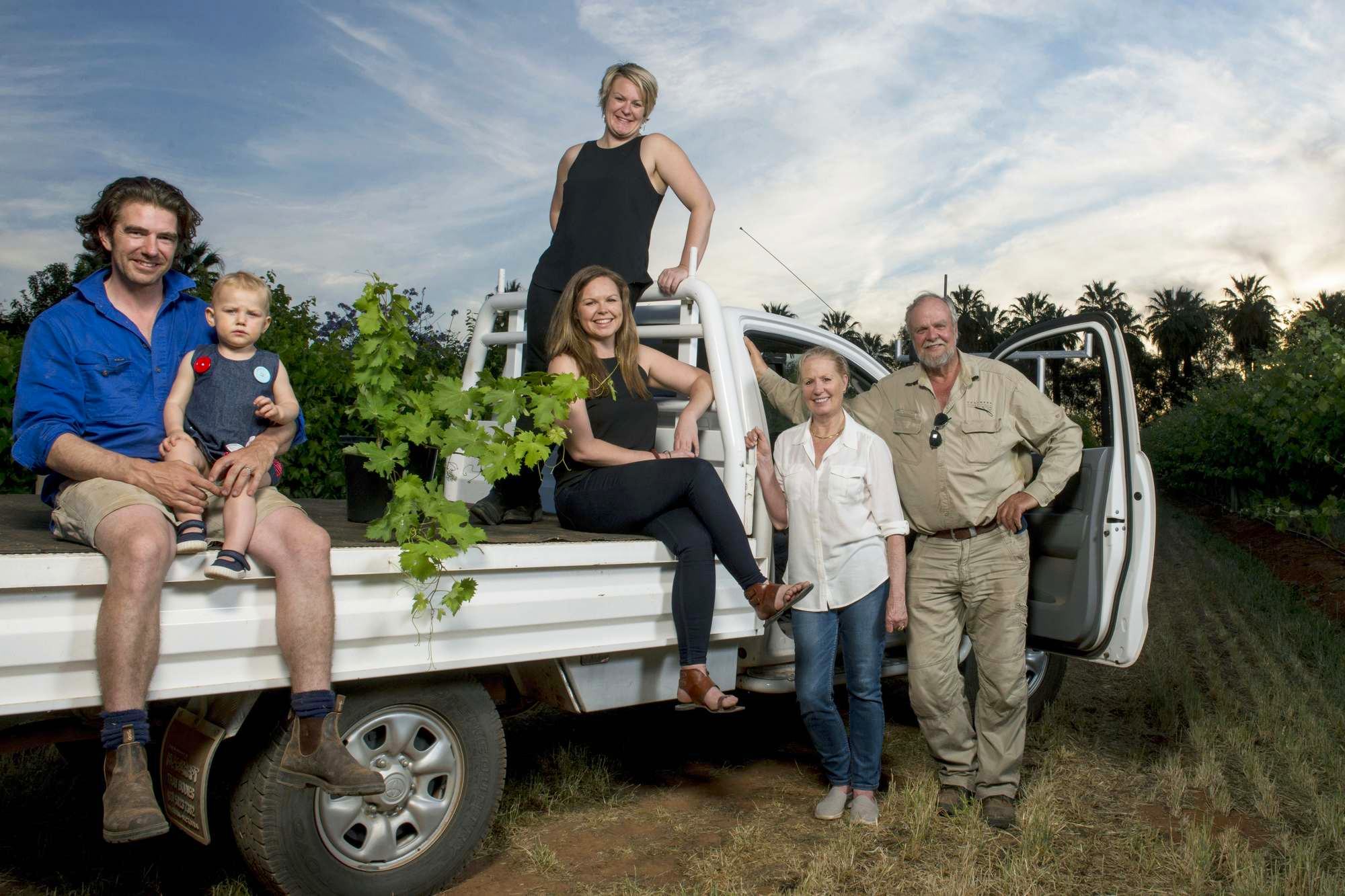 Three generations of the Chalmers family among the vines at sunset, gathered around a farm ute