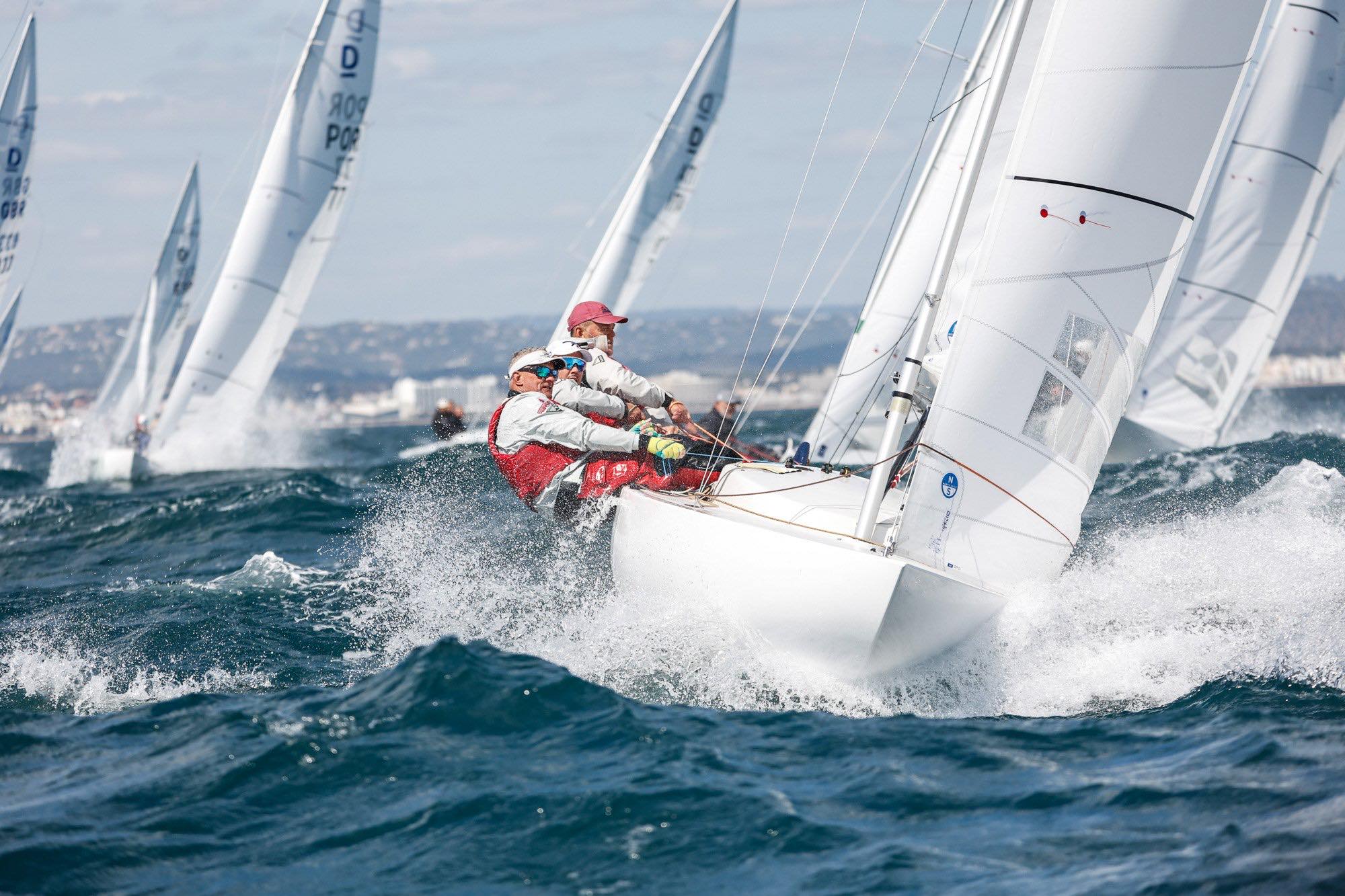 Dragons racing upwind in a steep sea, the leading boat carrying North Sails