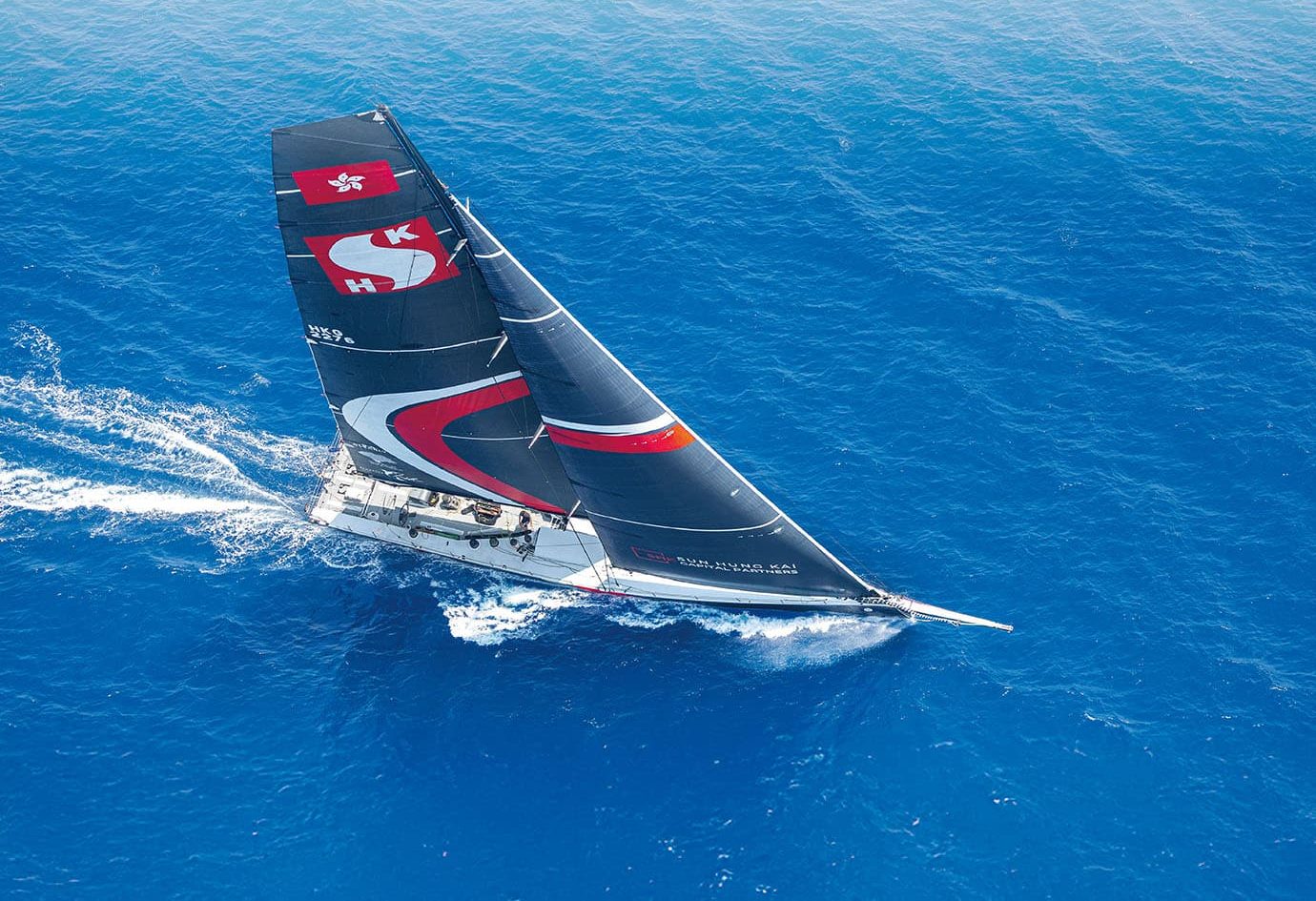 A maxi yacht in Sun Hung Kai & Co. colours racing offshore.