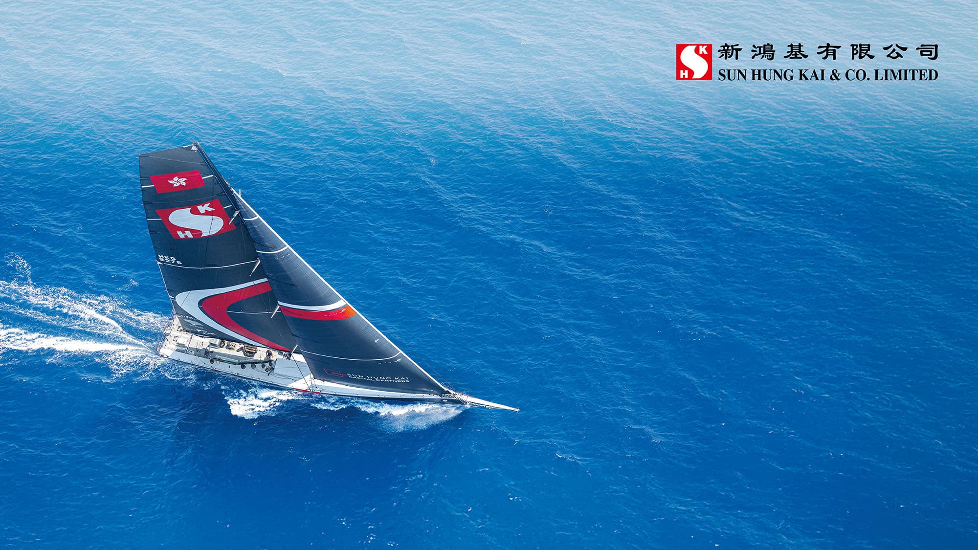 A maxi yacht in Sun Hung Kai & Co. colours racing offshore under the Hong Kong flag